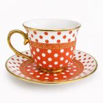 Taza de porcelana con lunares y plato