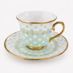 Taza de porcelana con lunares y plato